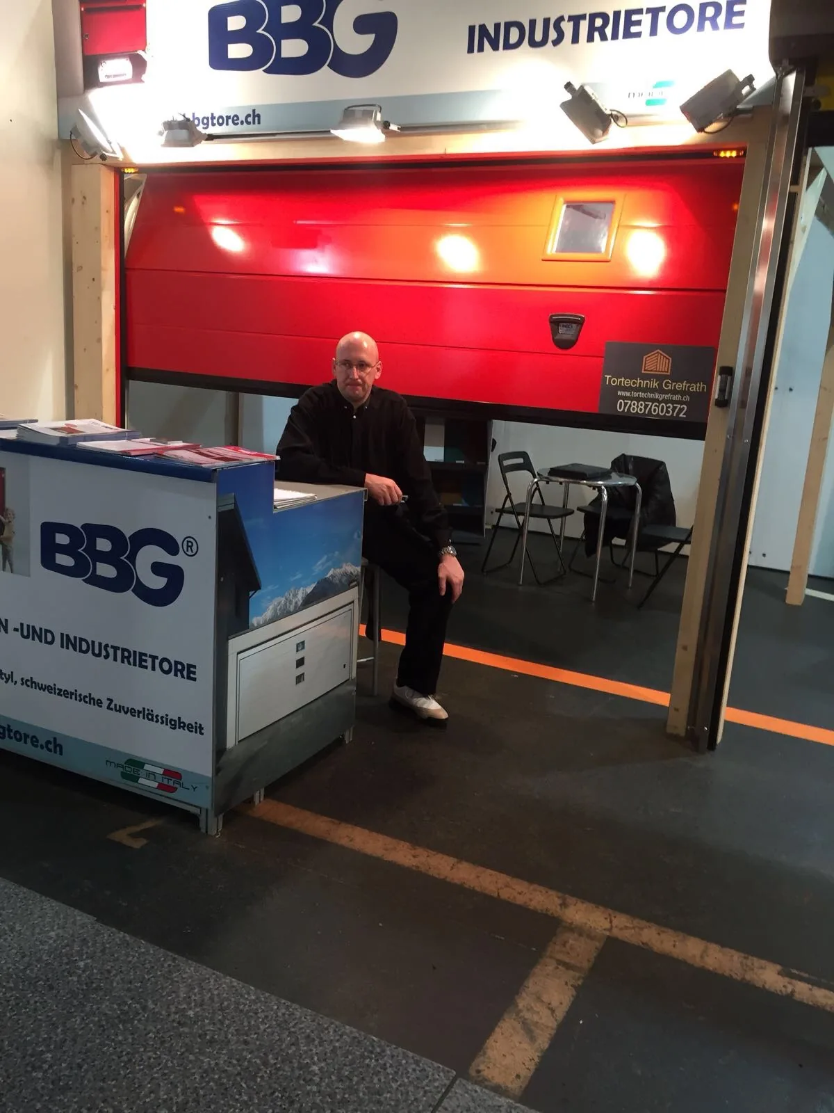 Andreas Grefrath, Inhaber von Tortechnik Grefrath, am Messestand vor einem Sektionaltor