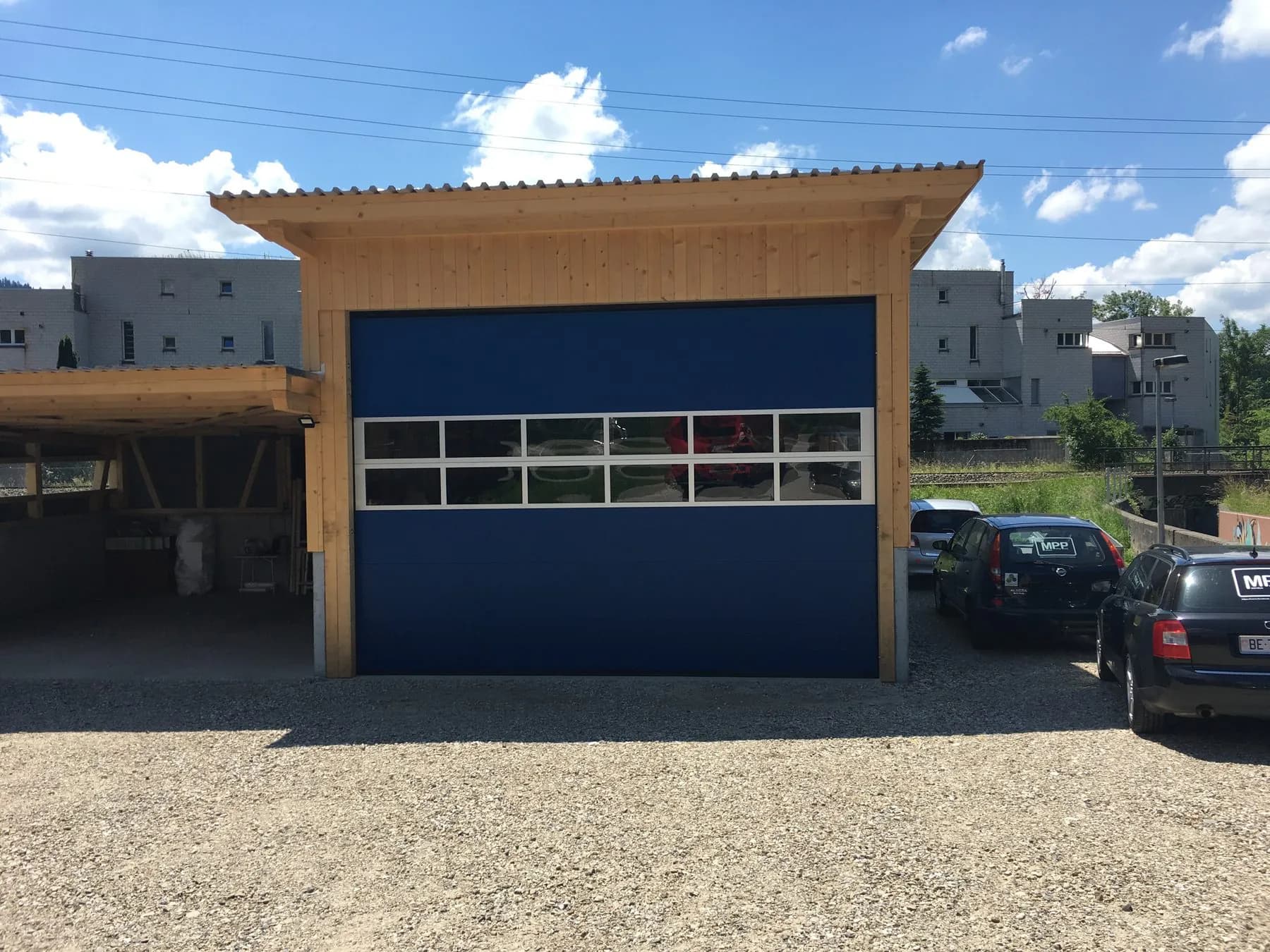 Blaues Industrietor mit Lichtband in einem Holzrahmen